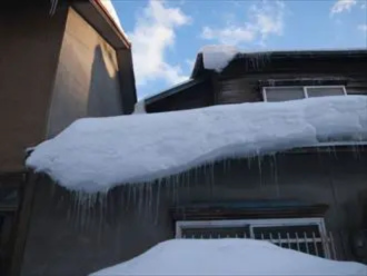 屋根の上に積雪しているお住まい